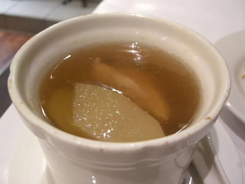 Double-boiled chayote and chicken soup in a white tureen