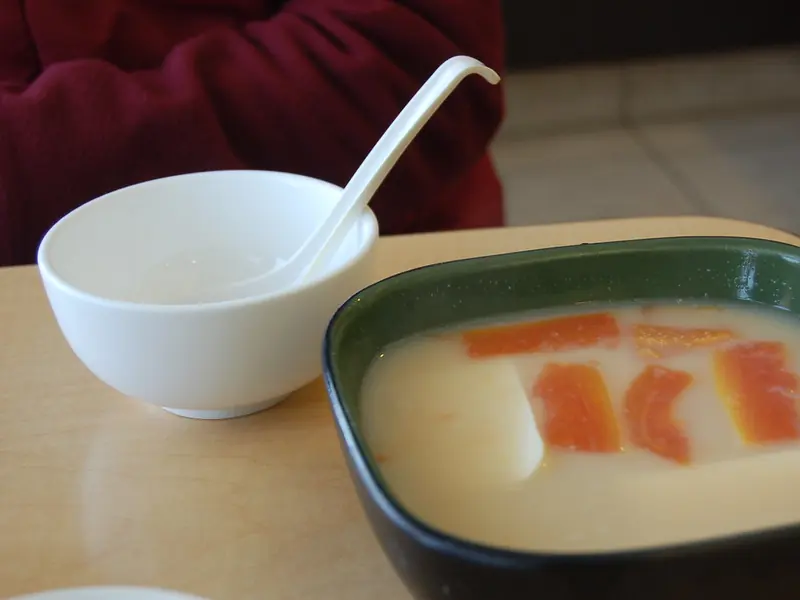 Milky papaya and fish soup with a small bowl and spoon