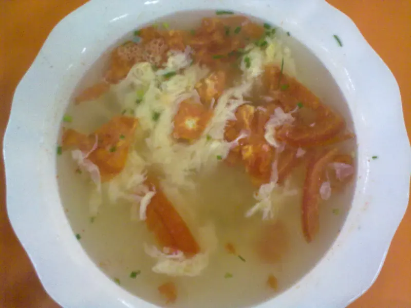 Tomato and egg drop soup in a white bowl