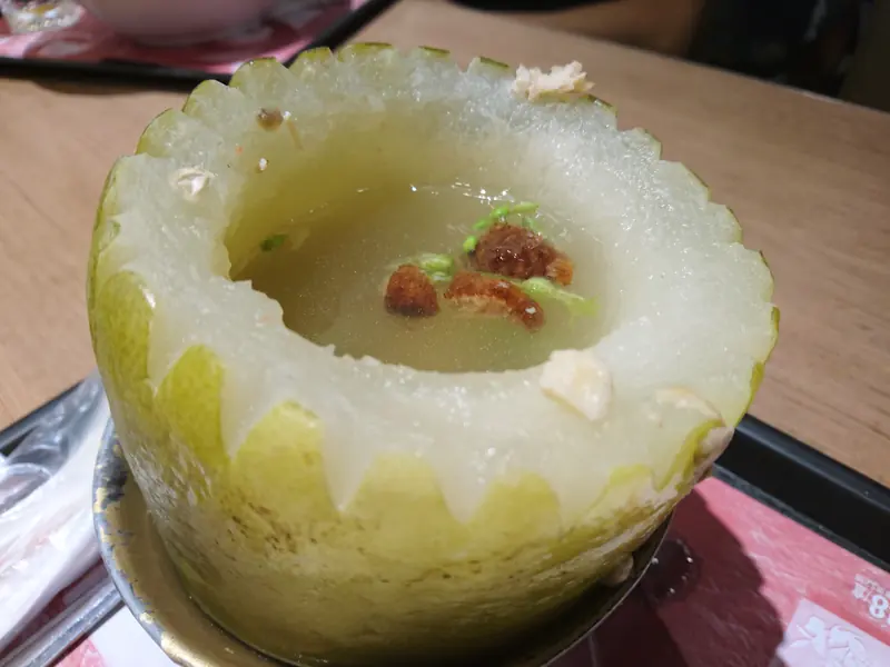 A small carved winter melon cup filled with soup